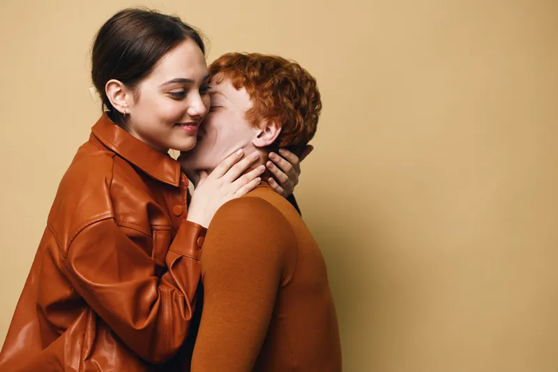 Couple with love and affection showing intimacy and tenderness, two people hugging and embracing, gentle moment between woman and man on beige background.