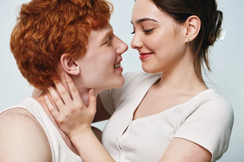 Couple, love, romance, intimacy and affection with woman holding man face close together for tender moment and happiness in relationship indoors in studio.