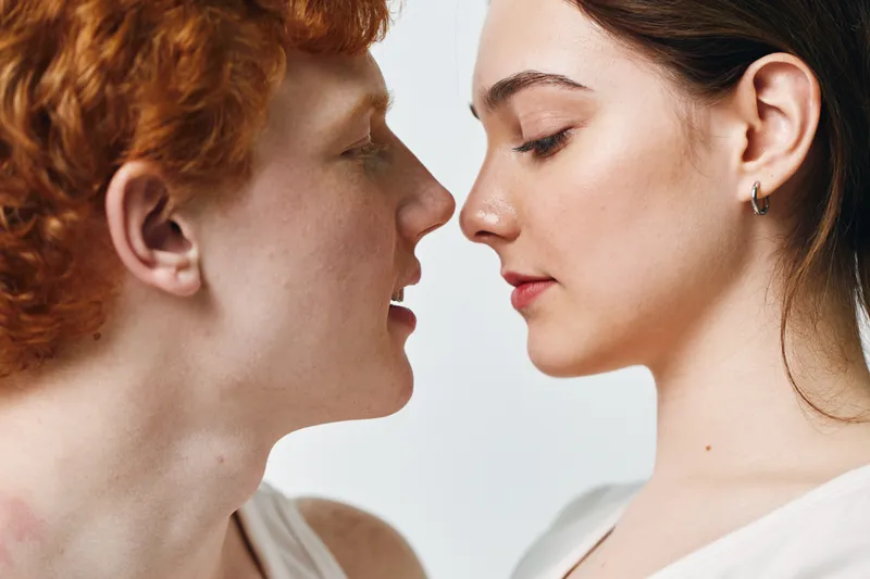 Couple, face, closeup and intimacy with young man and woman looking at each other gently in studio. Emotion, connection and love for relationship, affection and trust between two people.