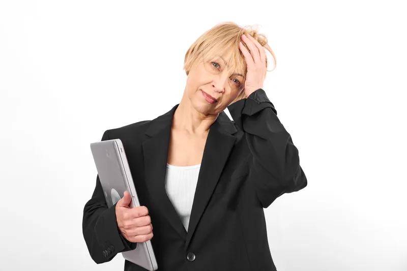 Elderly woman, holding planner, book in hands, touch head, looks frustrated and worry, mature portrait, studio lighting, white background, copy space