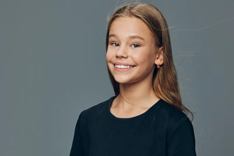 Girl, smile and portrait with happy face for childhood, youth and positive emotion in studio. Teenager, casual clothes and long hair for health and happiness concept.
