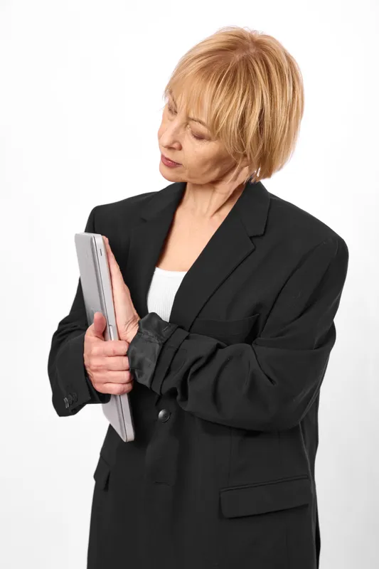 Businesswoman portrait professional woman in a black suit holds a tablet thinking with worried stress isolated on a white background conveying workplace anxiety and tension.