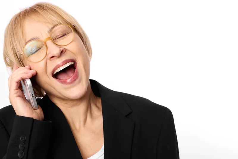 Woman smiling while talking on smartphone, business call in office setting, close up portrait with soft light, friendly communication and modern workplace concept, confidence