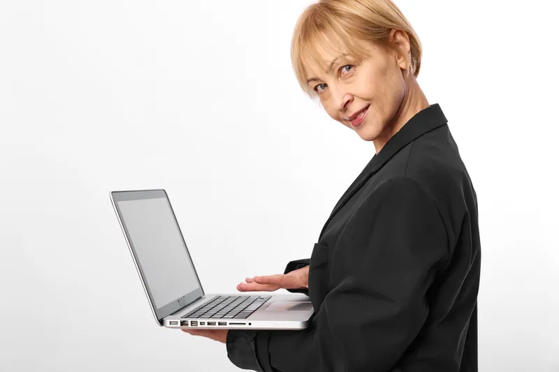 Stressed woman works on laptop in a clean studio, business office mood, tense posture and focused gaze show stress, remote communication and technology for modern work today