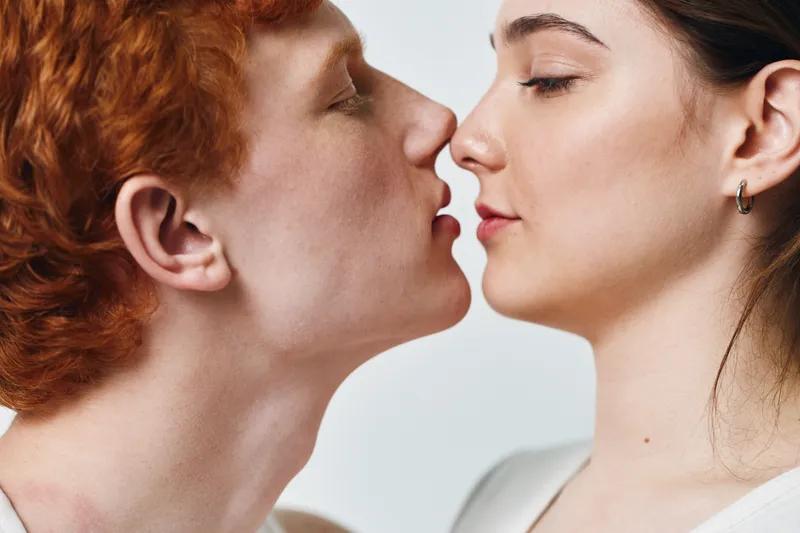 Couple, love, intimacy, closeup, romance, affection, passion, young, man, woman with eyes closed and lips about to kiss on white background.