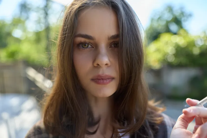 Natural outdoor portrait of a woman in a lifestyle setting, serene expression, candid moment daytime gaze with soft sunlight and fresh air showcasing simple beauty