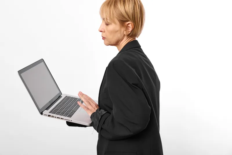 Woman laptop typing office work side view focused on screen professional business person working on computer in studio with clean white background isolated today