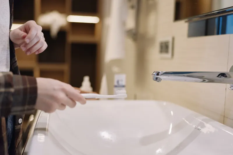 Closeup of hands at a sink, soap and water in use, emphasizing hygiene and cleanliness during daily handwashing routine in an indoor bathroom setting.