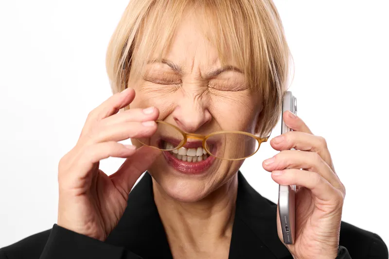 Woman with glasses holding eyewear in a closeup portrait, senior smile with eyes closed, studio light, vision care and wellness concept self care focus.