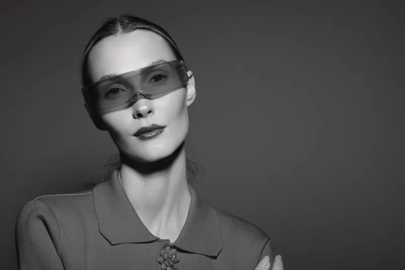 Close-up portrait of a fair skinned Caucasian woman wearing futuristic sunglasses and a textured jacket. Concept for fashion, style, elegance, modern accessories.