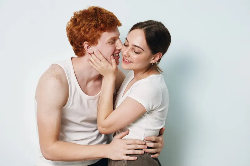 Couple, love, affection and young man with woman in close embrace for romance, relationship and happiness. Friendship, connection, casual clothing and smiling together with tender moment.