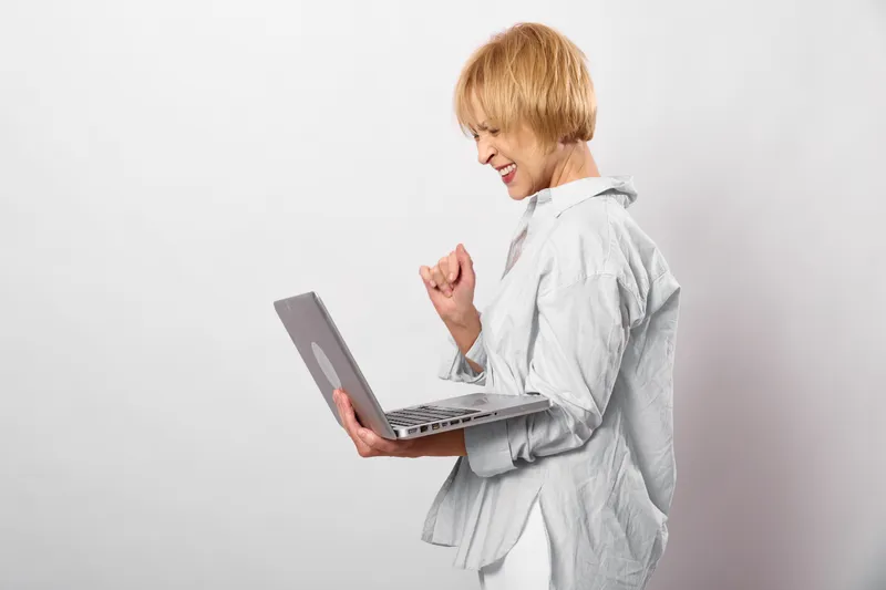 Girl with laptop on white background showing illness, cough and cold symptoms, hand near mouth, expression, healthcare concept for flu and respiratory prevention