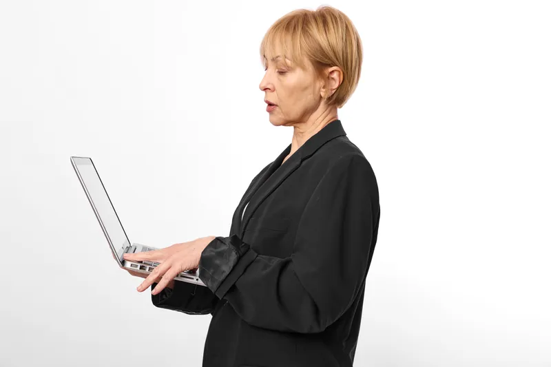 Woman using tablet in profile view, studio on white background, focused business technology concept, communication with modern digital device for work