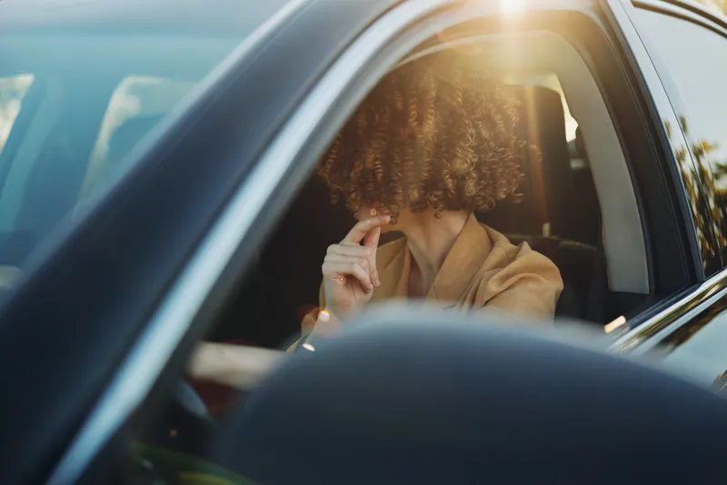 Woman driver in a car, a confident portrait with lifestyle vibe and warm sunlit tones through the window, showcasing everyday travel mood