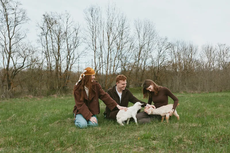 Goat kid outdoors lifestyle animals family countryside field friends nature meadow sunlight candid moment joy companionship farm rustic rural landscape grass open space guide cuddle play curious