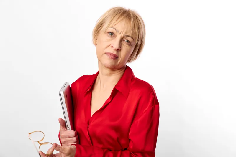 Woman senior portrait red blouse smartphone isolated white background confident communication screen in hand calm expression studio lighting minimal backdrop for online messaging and calling