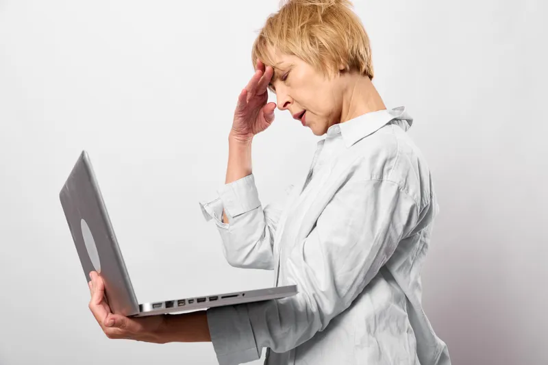 Woman laptop headache stress tired technology office communication health, employee holds laptop touching ear eyes closed unwell, isolated white background