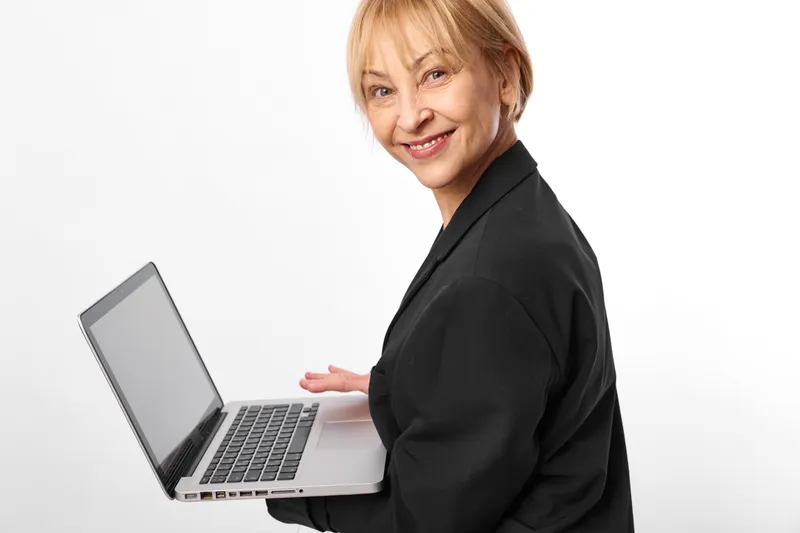 Woman laptop business studio portrait smiling senior woman black suit, looking at camera, relaxed pose, technology and communication concept against white background