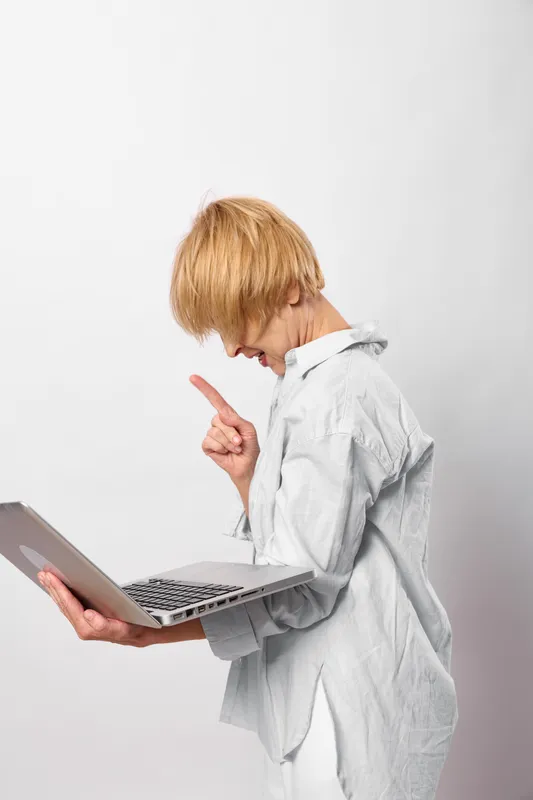 Child boy in white lab coat uses laptop for education and science learning, pointing gesture, focused on technology, clean studio background, isolated workspace.