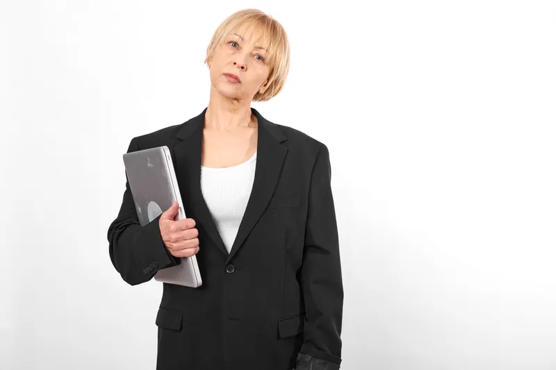 Older woman holding a tablet in a studio portrait on a white background, business communication concept, confident expression, modern technology, calm