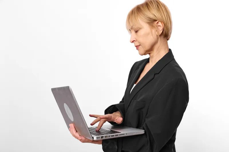Business woman uses laptop in office, corporate work with remote communication, typing and technology focus on white background, productivity concept, professional
