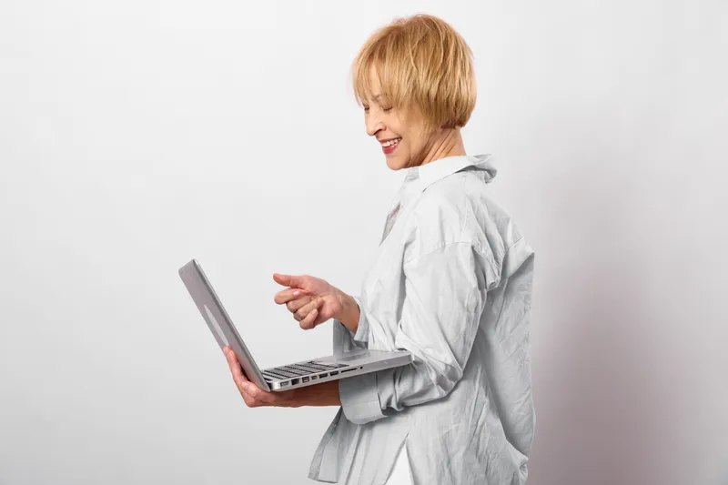 Woman laptop typing communication technology business remote work smile portrait, female adult with blond short hair working on keyboard, isolated on white background