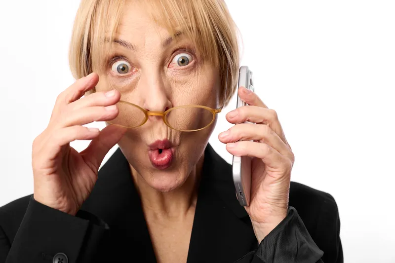 Woman with glasses in hands, studio portrait closeup, surprise and wide eyed facial expression, holding eyeglasses frames, white background, soft light, playful gesture, isolated