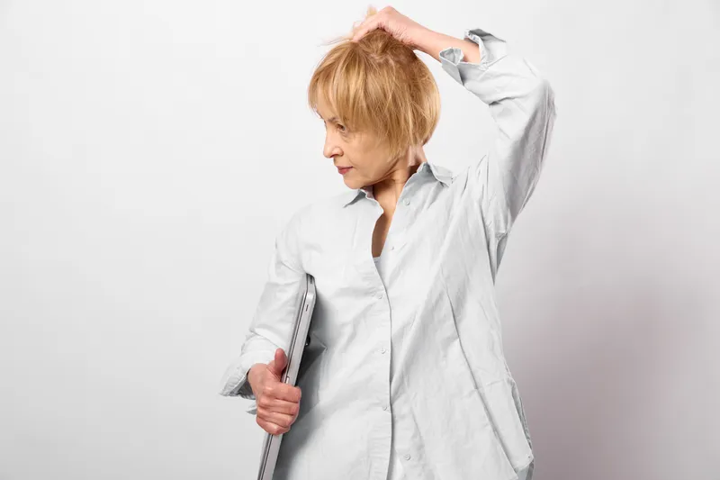 Stressed woman doctor nurse show burnout, stress, healthcare fatigue, hand on head, holding ruler, white coat, overwhelmed studio portrait
