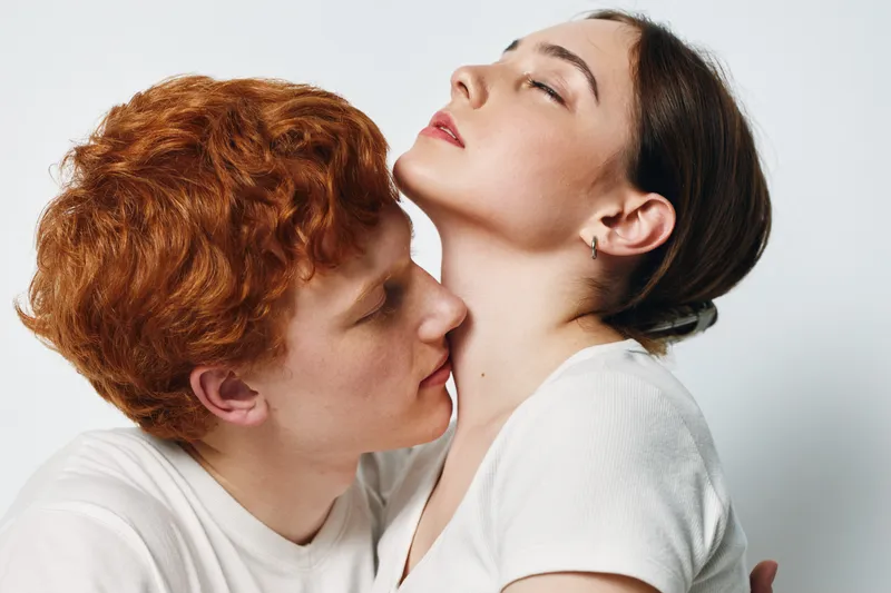 Couple, intimacy, redhead man and woman with closed eyes embracing gently, showing affection and connection in studio with white background and soft natural light.
