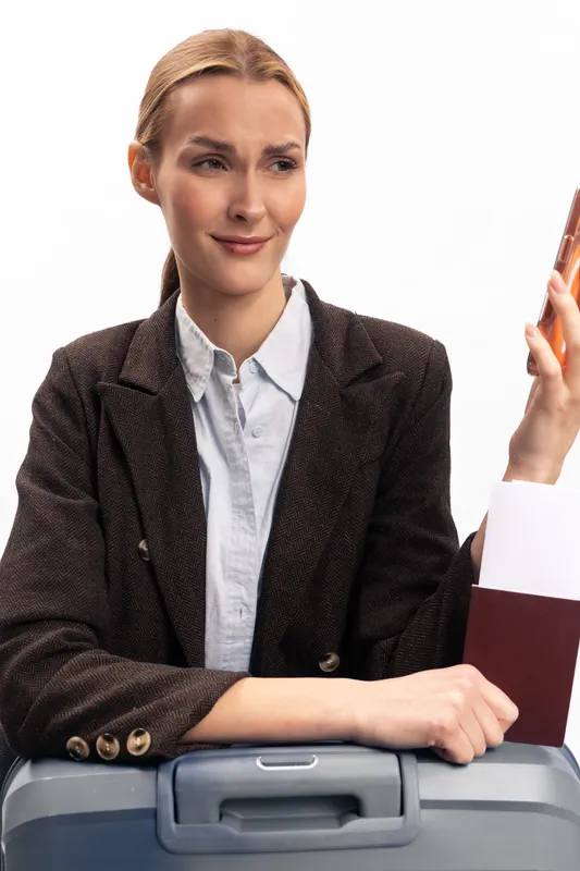Young woman holding passport and ticket looks confused and uncertain while sitting on suitcase. Travel concept with frustration and doubt about journey plans and documents.