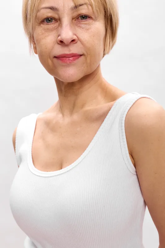 Senior woman portrait with calm face and subtle smile, light background, showcasing aging, confident wellbeing, and skincare care idea, studio closeup today