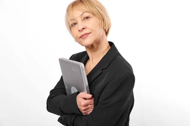 Woman business professional holding clipboard and tablet, senior manager portrait on white studio background, confident communication, corporate planning concept