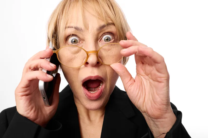 Woman funny surprise phone glasses nose mask expression comedy portrait, female in black blazer, holding smartphone, shocked open mouth, isolated on white