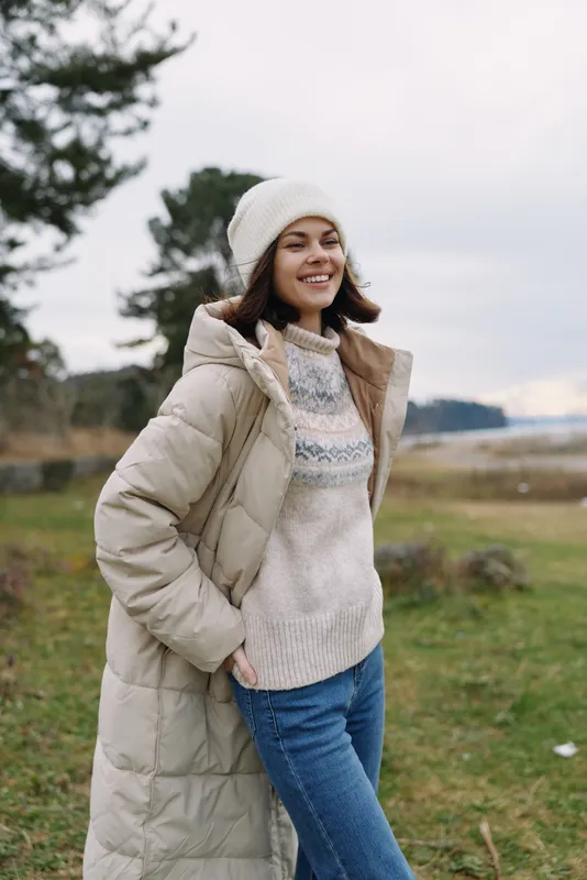 Winter fashion, outdoor, cozy outfit, warm coat, casual style, smiling woman posing in a field wearing a knit sweater and beanie, with soft natural light and a gentle breeze.