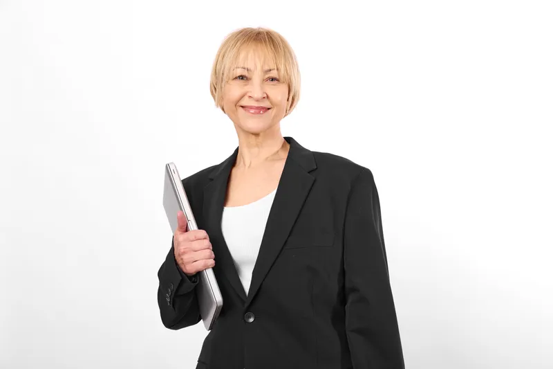 Woman senior tablet technology business smile blazer portrait, studio white background, holding tablet confidently, modern work communication, soft lighting.