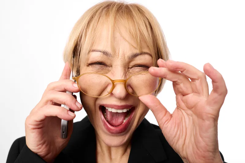 Woman with glasses and a smile, closeup portrait of an aging senior adjusting eyewear, joyful vision, studio white background, happy mood for sight care.