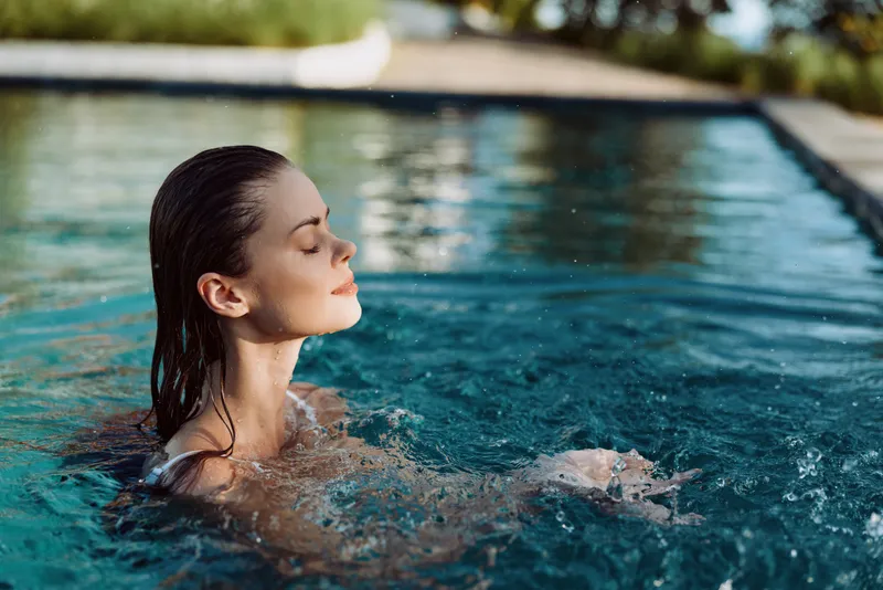 Relaxing pool moment with a woman enjoying sunlit water, outdoors scene, serene mood, and a casual lifestyle vibe, capturing a refreshing, carefree summer vibe