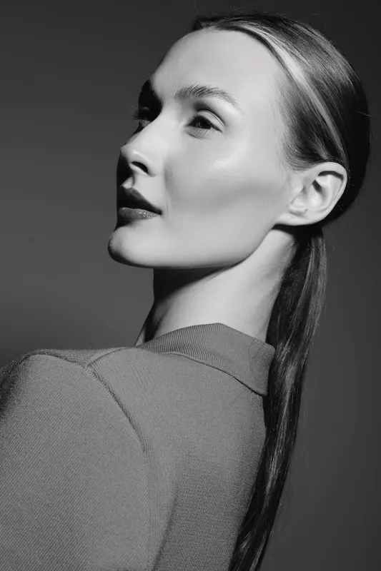 Profile of a young white woman with fair skin and sleek hair in studio lighting. Concept of beauty, minimalism, and natural skincare portrait.