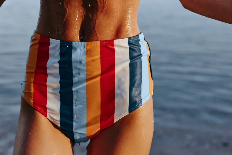 Swimmer striped swimwear swimsuit briefs bathing torso sea ocean water closeup, colorful vertical stripes, wet skin, male model, standing at shore, beach summer holiday, relaxed leisure