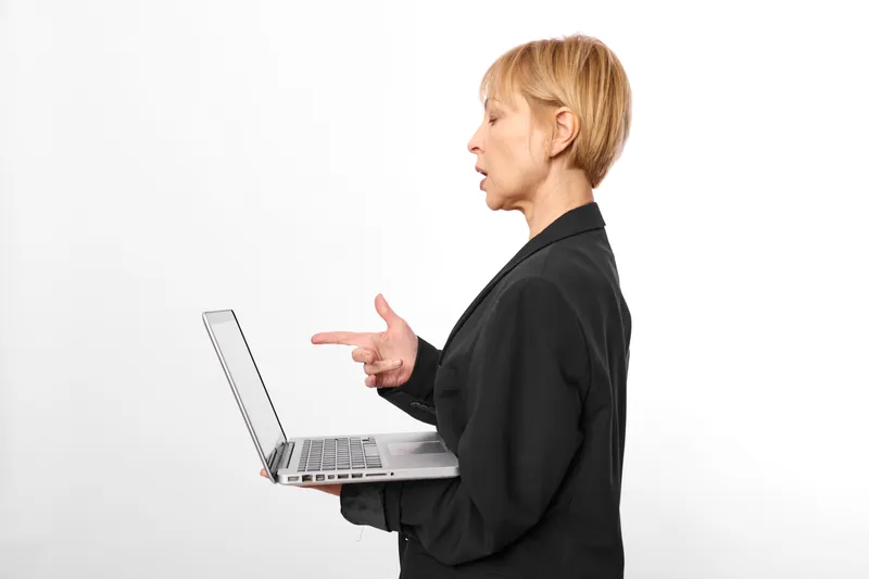 Woman using laptop in side profile, business communication gesture, professional working moment, office background, typing and presentation of ideas, modern technology concept