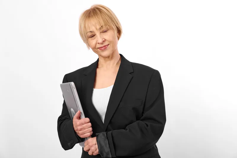 Woman reading a book with smile in a business blazer on a clean white background close up portrait conveys education study and calm confidence Soft studio lighting