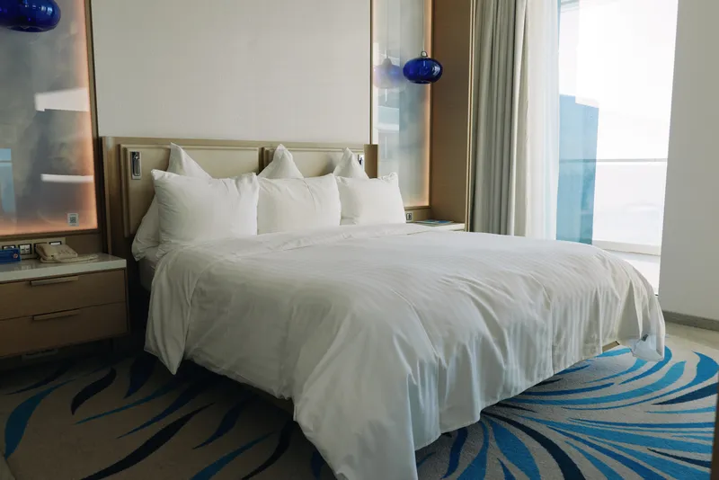 hotel bed room luxury white linens, bright contemporary space with plush pillows and clean lines, inviting comfortable stay and calm atmosphere during night