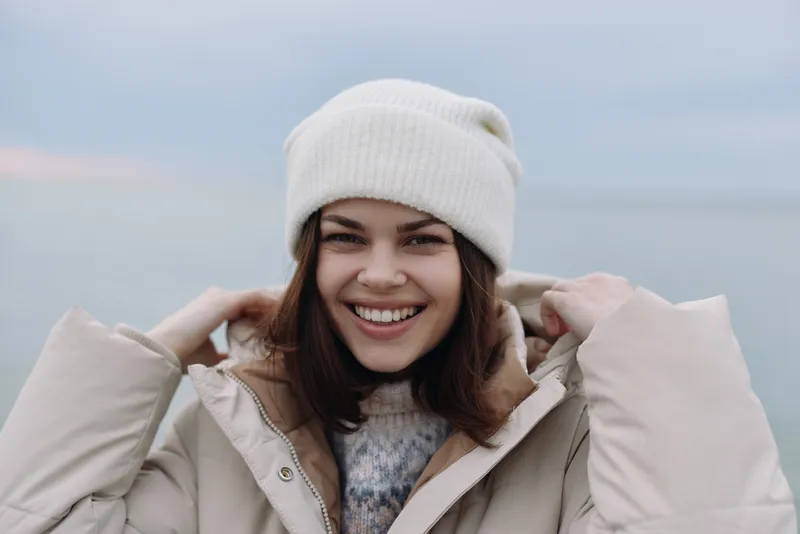 Woman portrait in winter outdoors, smiling in a cozy beanie and jacket, showcasing a casual and cheerful look for fashion, lifestyle and outdoor photography.