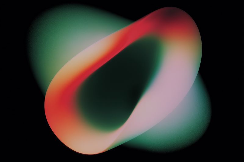 Glowing abstract loop formed by smooth gradients of red, green and pink against a deep black background, featuring an ethereal silky texture, subtle grain and luminous light effects.