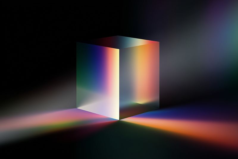 A photorealistic glass cube prism illuminated by multicolored light beams creating vibrant spectrum reflections and soft gradients across a dark surface for a modern abstract composition.
